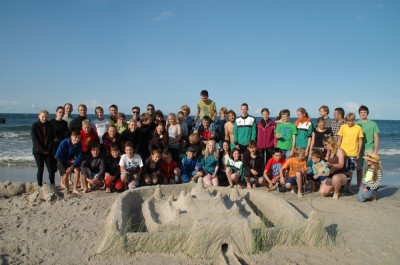 die Teilnehmer vor einem von einigen selbstgebauten Schloss aus Sand auf der Halbinsel Hel